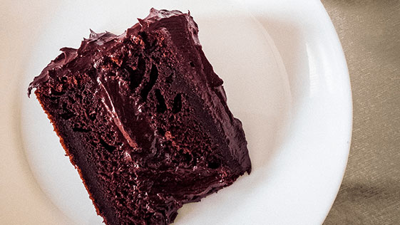 Imagem de um prato com um pedaço de bolo de chocolate.